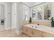 Elegant bathroom featuring a soaking tub with travertine accents and plenty of natural light at 141 S Phelps Ave, Winter Park, FL 32789
