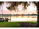 Scenic lake view at sunset with dock, tranquil waters, and Spanish moss hanging from trees at 141 S Phelps Ave, Winter Park, FL 32789