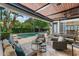 Covered outdoor living space with a built-in kitchen, comfortable seating, and pool view at 141 S Phelps Ave, Winter Park, FL 32789