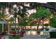 Resort-style pool area with lounge chairs, lush landscaping, and tranquil waterfront views at 141 S Phelps Ave, Winter Park, FL 32789