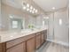 Bright bathroom with dual sink vanity, large mirror, and glass-enclosed shower at 14244 Walcott Ave, Orlando, FL 32827