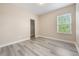 Neutral bedroom with grey laminate flooring, a window, and a door to the closet at 14244 Walcott Ave, Orlando, FL 32827