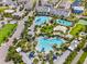 Aerial image showcases the community pool area with pools, a volleyball court, palm trees, and parking at 14244 Walcott Ave, Orlando, FL 32827