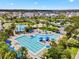 Aerial view of the community pool and amenities with blue umbrellas and multiple palm trees in a planned neighborhood at 14244 Walcott Ave, Orlando, FL 32827