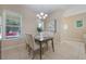 Sunlit dining area features tile floors, modern chandelier and room for four guests at 14244 Walcott Ave, Orlando, FL 32827