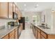 Modern kitchen with stainless steel appliances, granite counters, and a seamless layout into the dining room at 14244 Walcott Ave, Orlando, FL 32827