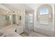 Bright bathroom featuring dual sinks, vanity, a shower, and a soaking tub by the window at 144 Henue Ct, Davenport, FL 33896