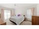 Cozy bedroom with a comfortable bed, side table, and natural light from the windows at 144 Henue Ct, Davenport, FL 33896
