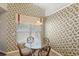 Cozy breakfast nook with a glass-top table, floral wallpaper, and a bright window at 144 Henue Ct, Davenport, FL 33896