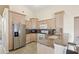 Bright kitchen with stainless steel appliances, light wood cabinets, and tiled flooring at 144 Henue Ct, Davenport, FL 33896