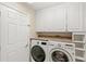 Bright laundry room featuring a modern washer and dryer, storage cabinets and laminate countertops at 144 Henue Ct, Davenport, FL 33896