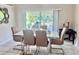 Bright dining area with a modern table, stylish chairs, and a view of the green outdoor space at 1449 Amanda Rd, Kissimmee, FL 34744