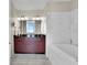 Luxurious bathroom featuring a marble-lined bathtub and a modern vanity with double sinks at 150 E Robinson St # 2002, Orlando, FL 32801