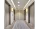 Hallway leading to elevators featuring modern lighting, carpet, and neutral colors at 150 E Robinson St # 2002, Orlando, FL 32801