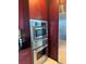 Modern kitchen appliances with stainless steel wall ovens and dark wood cabinets at 150 E Robinson St # 2002, Orlando, FL 32801
