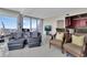 Inviting living room with dark couches, patterned chairs, and city views through large windows at 150 E Robinson St # 2002, Orlando, FL 32801