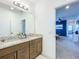Bathroom with a double vanity, granite countertops and view to living space at 15959 Pantuso Aly, Winter Garden, FL 34787