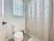 Clean bathroom featuring a toilet, shower with curtain, and a window at 15959 Pantuso Aly, Winter Garden, FL 34787