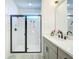 Stylish bathroom with a glass shower door and a single vanity sink with black accents at 15959 Pantuso Aly, Winter Garden, FL 34787