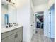 Well-lit bathroom with a modern vanity, decorative flooring, and an open closet space at 15959 Pantuso Aly, Winter Garden, FL 34787