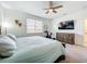 A light-filled bedroom featuring a ceiling fan, carpet floors and a large window at 15959 Pantuso Aly, Winter Garden, FL 34787