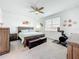 Bright bedroom with a wooden bed frame, a ceiling fan, and carpet floors at 15959 Pantuso Aly, Winter Garden, FL 34787