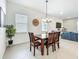 Dining area next to a living space featuring a wood table and an elegant chandelier at 15959 Pantuso Aly, Winter Garden, FL 34787