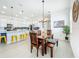 Open-concept dining area boasts a wooden table with seating adjacent to a modern kitchen at 15959 Pantuso Aly, Winter Garden, FL 34787