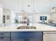 Open kitchen showcasing a large island with double sink and the combined living spaces at 15959 Pantuso Aly, Winter Garden, FL 34787