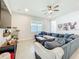Relaxing living room features a large blue sectional sofa, ceiling fan and light wood-look floors at 15959 Pantuso Aly, Winter Garden, FL 34787