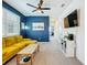 Relaxing loft area features a modern yellow sofa, blue accent wall and soft carpeting at 15959 Pantuso Aly, Winter Garden, FL 34787