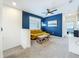 Cozy loft space features a stylish yellow sofa, blue accent wall, and soft carpeting at 15959 Pantuso Aly, Winter Garden, FL 34787