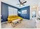 Stylish loft area boasts a comfortable yellow sofa, blue accent wall and soft carpeting at 15959 Pantuso Aly, Winter Garden, FL 34787