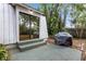 Backyard with concrete patio, steps leading to a sliding glass door, and lush foliage at 1650 Old Eustis Rd, Mount Dora, FL 32757