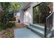 Backyard patio with steps leading to a sliding glass door and tropical plants at 1650 Old Eustis Rd, Mount Dora, FL 32757