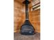 Close-up of a unique cone-shaped fireplace with brick base, adding a rustic and cozy focal point to the wood-paneled room at 1650 Old Eustis Rd, Mount Dora, FL 32757