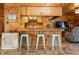 Open bar area featuring wood paneling, seating for three, and seamless access to the kitchen, perfect for casual dining at 1650 Old Eustis Rd, Mount Dora, FL 32757