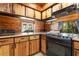 Well-equipped kitchen with knotty pine cabinets, stainless steel appliances, and a comfortable living area at 1650 Old Eustis Rd, Mount Dora, FL 32757