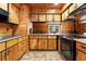 Knotty pine kitchen featuring modern appliances, black countertops, and ample cabinet space at 1650 Old Eustis Rd, Mount Dora, FL 32757