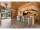 Open-concept living space with knotty pine walls, tiled flooring, and access to the backyard at 1650 Old Eustis Rd, Mount Dora, FL 32757