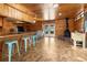 Spacious living area with knotty pine walls, open to the kitchen, and a striking modern fireplace at 1650 Old Eustis Rd, Mount Dora, FL 32757