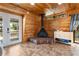 Cozy living room with wood-paneled walls, fireplace, and access to the outdoors at 1650 Old Eustis Rd, Mount Dora, FL 32757