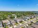 Beautiful aerial view of a residential neighborhood with lush green trees and a sparkling lake in the distance at 17226 Hickory Wind Dr, Clermont, FL 34711