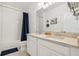 Bathroom featuring a double sink vanity with marble countertop and shower-tub combo, with white tiled walls at 17226 Hickory Wind Dr, Clermont, FL 34711