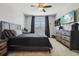 Relaxing bedroom featuring a ceiling fan, a large window, and coordinating dark grey furniture and accents at 17226 Hickory Wind Dr, Clermont, FL 34711