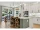 Bright kitchen features a center island with barstool seating, pendant lights and white cabinets at 17226 Hickory Wind Dr, Clermont, FL 34711