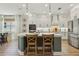 Open-concept kitchen boasts a center island with barstool seating, white cabinets, and stainless steel appliances at 17226 Hickory Wind Dr, Clermont, FL 34711