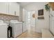 Well-organized laundry room with patterned backsplash, washer, dryer, and bench seat at 17226 Hickory Wind Dr, Clermont, FL 34711