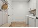 Functional laundry room with white washer and dryer, cabinets, and convenient bench at 17226 Hickory Wind Dr, Clermont, FL 34711