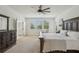 Bright main bedroom features neutral carpet, ceiling fan, and sunny windows at 17226 Hickory Wind Dr, Clermont, FL 34711